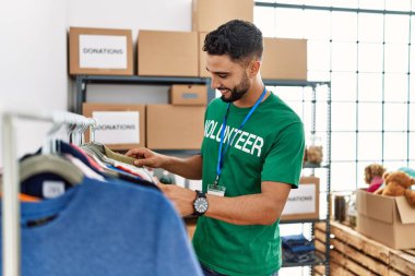 Gönüllü üniformalı genç bir Arap hayır kurumunda çalışıyor.