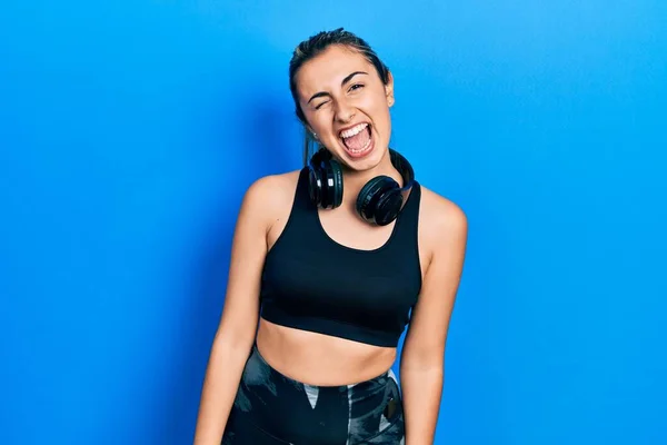 Hermosa Mujer Hispana Vistiendo Ropa Gimnasio Usando Auriculares Guiñando Ojo — Foto de Stock