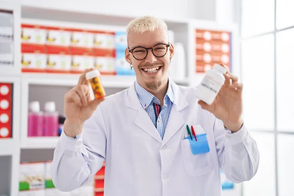 Young Caucasian Man Pharmacist Holding Pills Bottles Pharmacy — Foto de Stock