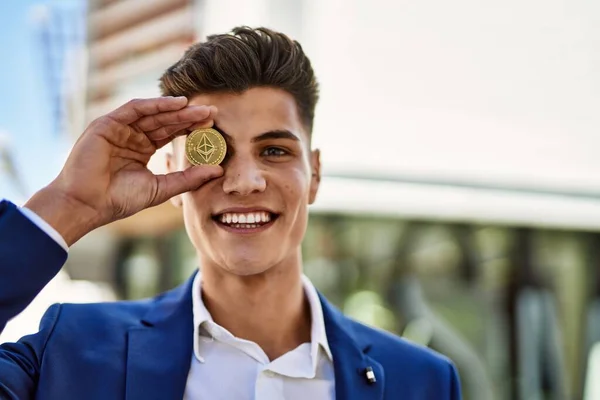 Young man wearing suit holding ethereum over eye at street
