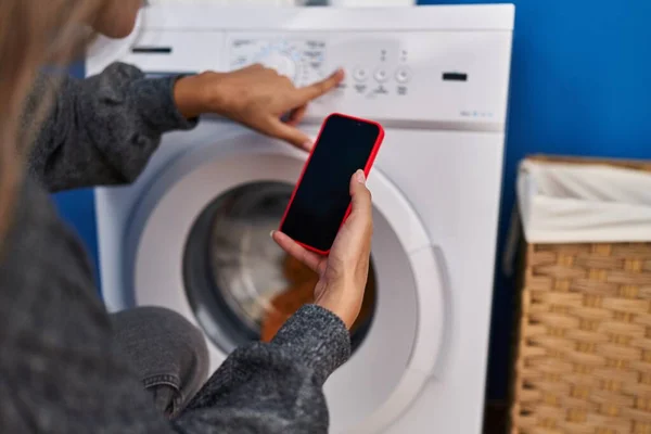 Çamaşır Odasında Çamaşır Makinesi Bekleyen Akıllı Telefon Kullanan Genç Sarışın — Stok fotoğraf