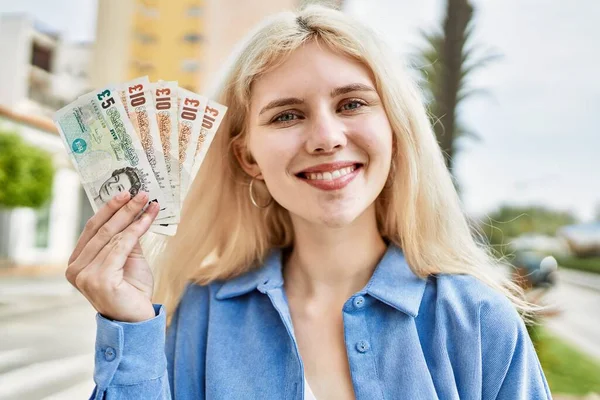 Νεαρή Ξανθιά Γυναίκα Που Κρατάει Αγγλικά Χαρτονομίσματα Δείχνοντας Χρήματα Χαμογελώντας — Φωτογραφία Αρχείου