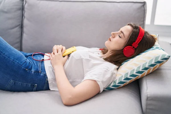 Young Woman Listening Music Sleeping Sofa Home — Stockfoto