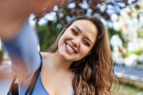 young hispanic girl smiling happy make selfie by the camera at the city.