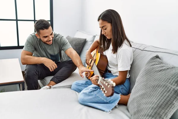 Jovem Casal Latino Tocando Guitarra Clássica Sentado Sofá Casa — Fotografia de Stock