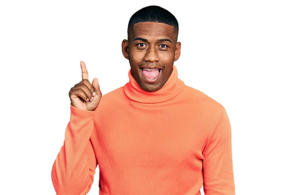 Junger Schwarzer Mann Orangefarbenem Rollkragenpullover Mit Erhobenem Zeigefinger Und Erfolgreicher — Stockfoto