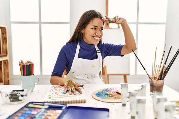 塗装手とアートスタジオで若いブルネットの女性は非常に満足し 頭の上に手で遠くを見て笑っています 検索の概念 — ストック写真