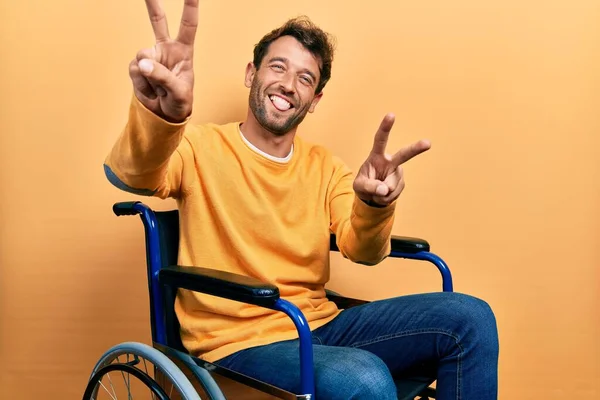 Tekerlekli Sandalyede Oturan Sakallı Yakışıklı Iki Elini Göstererek Gülümseyerek Zafer — Stok fotoğraf