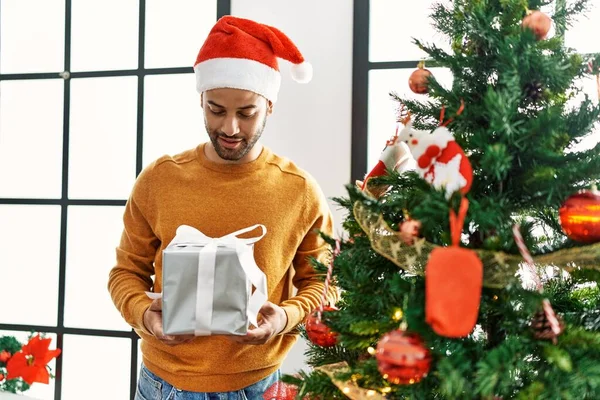 Young Arab Man Smiling Happy Holding Gift Standing Christmas Tree — Stock Photo, Image