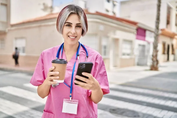 年轻的高加索医生妇女在城市里喝咖啡和使用智能手机 — 图库照片