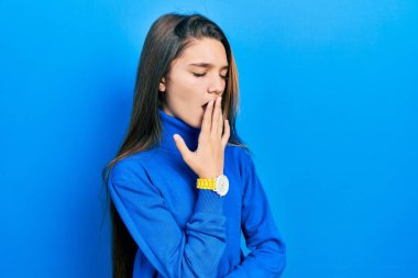 Balıkçı yaka kazak giyen genç esmer kız ağzını eliyle kapatmaktan sıkılmış. Huzursuz ve uykulu.. 