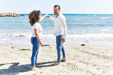 Orta yaşlı İspanyol çift gülümsüyor sahilde mutlu bir şekilde dans ediyor..