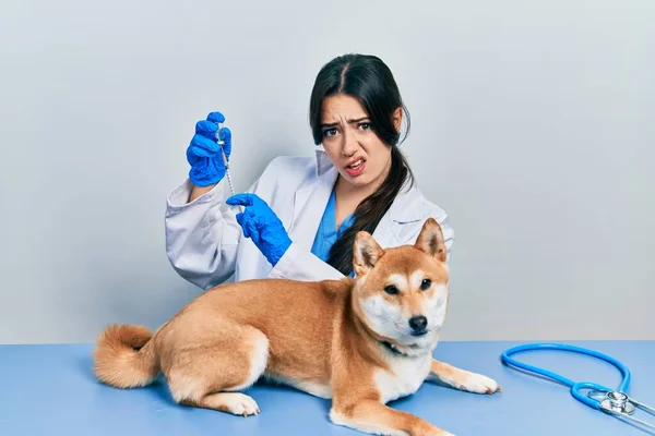 他那漂亮的惊慌失措的兽医女人 在震惊的脸上给小狗注射疫苗 脸上带着怀疑和讽刺的表情 张大了嘴 吃惊极了 — 图库照片