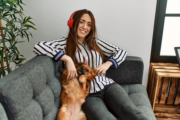 Young Hispanic Woman Listening Music Sitting Sofa Dog Home — Fotografia de Stock