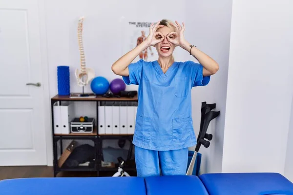 Young Physiotherapist Woman Working Pain Recovery Clinic Doing Gesture Binoculars — Stockfoto