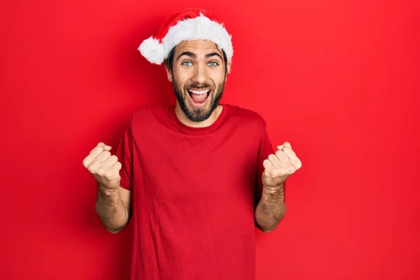 Young Hispanic Man Wearing Christmas Hat Celebrating Surprised Amazed Success — Stockfoto