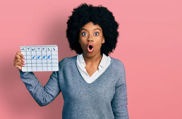 Young African American Woman Holding Travel Calendar Scared Amazed Open — Stockfoto
