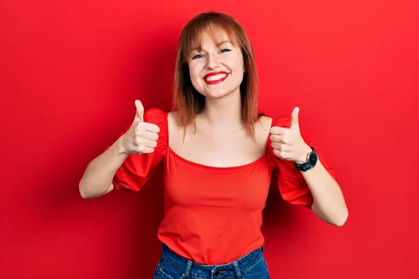 Kırmızı Tişört Giyen Kızıl Saçlı Genç Bir Kadın Başarı Işareti — Stok fotoğraf