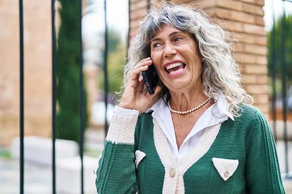 Orta Yaşlı Bir Kadın Gülümsüyor Sokakta Akıllı Telefondan Konuşuyor — Stok fotoğraf