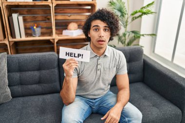 Kıvırcık saçlı İspanyol adam yardım istiyor. Korkmuş ve ağzı açık, şaşırmış ve şaşırmış. 