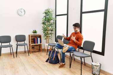 Genç İspanyol adam gülümsüyor. Bekleme odasında kendine güvenen bir video var.