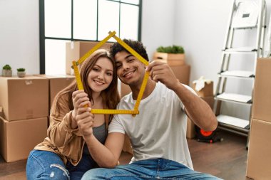 Genç çift yeni evinde mutlu bir ev projesiyle gülümsüyor..