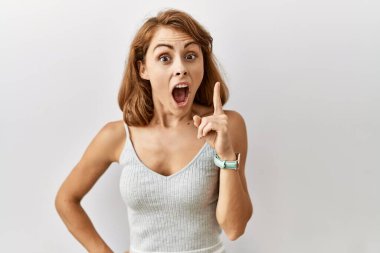 İzole edilmiş arka planda duran güzel beyaz kadın başarılı bir fikir işaret ediyor. Heyecanlı ve mutlu. Bir numara.. 