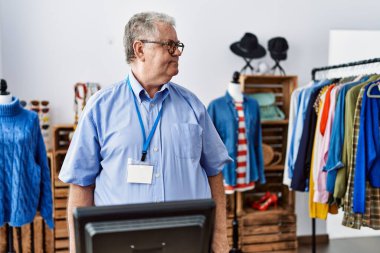 Gri saçlı yaşlı adam perakende mağazasında müdür olarak çalışıyor. Taraf arıyor, rahat profil pozu veriyor. Kendine güvenen bir gülümsemesi var.. 