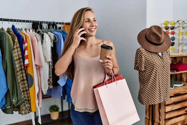 年轻的高加索女性顾客在服装店用智能手机购物 — 图库照片