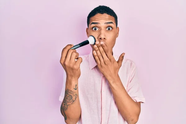 Young African American Guy Holding Makeup Brush Covering Mouth Hand — Stock Photo, Image