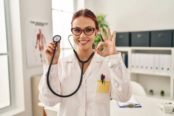 Mujer Joven Caucásica Vistiendo Uniforme Médico Usando Estetoscopio Haciendo Signo —  Fotos de Stock