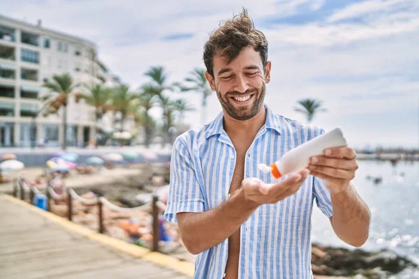Jovem Hispânico Sorrindo Feliz Usando Protetor Solar Loção Praia — Fotografia de Stock