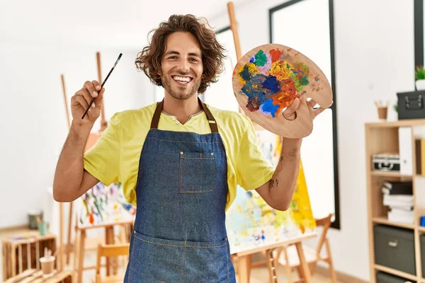 Joven Artista Hispano Sonriendo Feliz Sosteniendo Pincel Paleta Estudio Arte — Foto de Stock