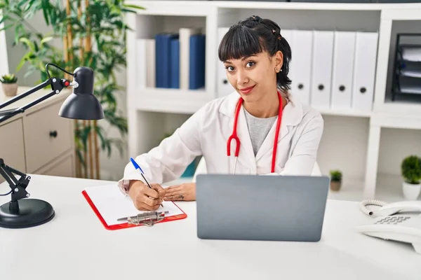 诊所里穿着医生制服 使用笔记本电脑的年轻妇女 — 图库照片