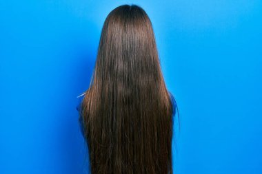 Balıkçı yaka kazak giyen genç esmer kız kollarını kavuşturup arkaya bakıyor. 