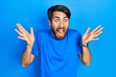 Sıradan kıyafetler giyen genç İspanyol adam çılgın ve başarıyı kollarını kaldırıp heyecanla haykırarak kutluyor. Kazanan konsept 