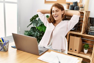 Kafkasyalı genç iş kadını, elleri ofiste çalışırken rahat..