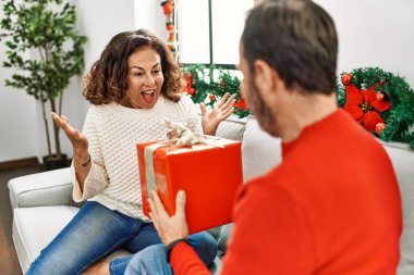Orta yaşlı İspanyol bir çift Noel hediyesi alıp evdeki kanepede oturuyor..
