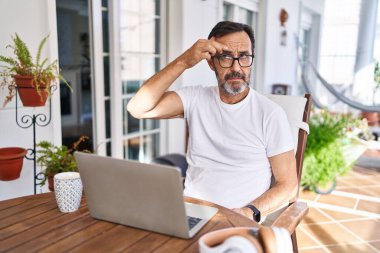 Orta yaşlı adam evde bilgisayar kullanıyor. Alnındaki sivilceden mutsuz olduğunu gösteriyor. Siyah nokta enfeksiyonu. sivilce ve deri problemi 