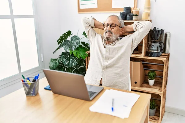 Kıdemli Gri Saçlı Adam Ellerini Başının Üstüne Koyup Ofiste Çalışıyor — Stok fotoğraf