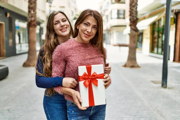 Mother Daughter Hugging Each Other Holding Birthday Gift Street — Stockfoto
