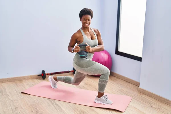African american woman smiling confident training legs exersice at sport center