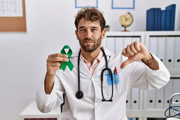 Joven Médico Hispano Sosteniendo Cinta Verde Apoyo Clínica Con Cara — Foto de Stock