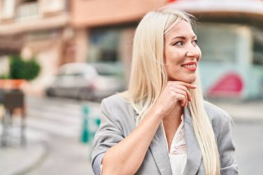 Sokakta kendine güvenen genç sarışın kadın gülümsüyor