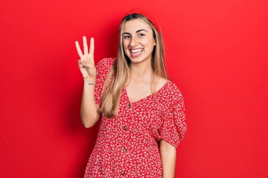 Güzel İspanyol kadın yaz elbisesi giyer ve üç numarayı göstererek gülümserken kendinden emin ve mutludur.. 