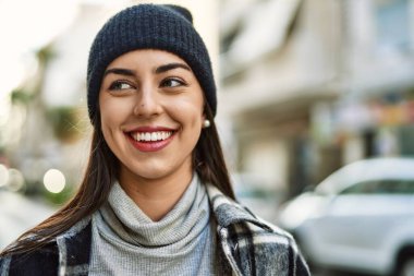 Genç İspanyol kadın gülümseyerek şehirde mutlu mesut dikiliyor..