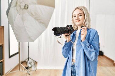 Fotoğrafçılık stüdyosunda profesyonel fotoğrafçı olarak çalışan güzel sarışın kadın. Sdxc bellek kartı duruyor