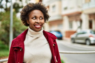 Güzel bir iş adamı Afro saçlı Amerikalı kadın şehirde mutlu ve kendinden emin bir şekilde gülümsüyor.
