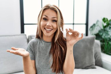 Kafkasyalı genç bir kadın, görünmez bir hizayı elinde tutarak başarıyı mutlu bir gülümsemeyle kutluyor ve kazanan el kaldırarak ifade ediyor. 