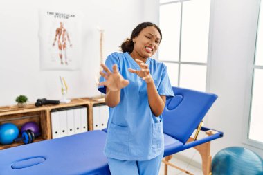 Ağrı kesici kliniğindeki güzel İspanyol fizyoterapist kadın tiksinti ifadesi, tiksinti tepkisi yüzünden tiksinti ve korku ifadesi takınıyordu. Eller havada. 